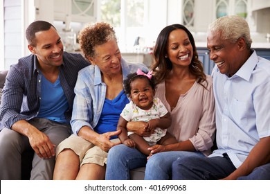 Grandparents And Parents With A Baby Girl On MumÃ¢??s Knee