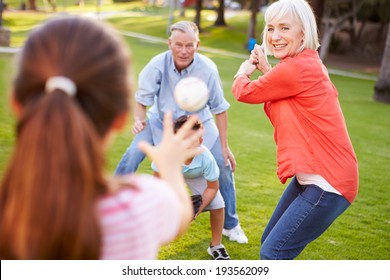 Grandparents Playing Baseball With Grandchildren In Park