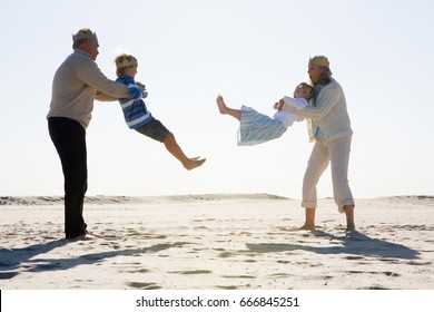 Grandparents Playing With Grandchildren On Beach