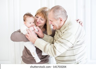 Grandparents Playing With A Newborn Baby Girl