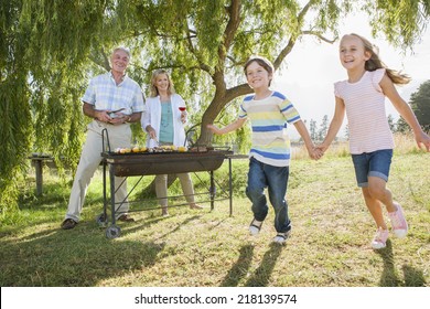 Grandparents Serving Grandchildren At Family Barbeque - Powered by Shutterstock