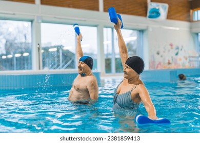 Grandparents taking care of their health. Senior adult caucasian married couple doing aqua fitness exercises with pool buoys. High quality photo - Powered by Shutterstock