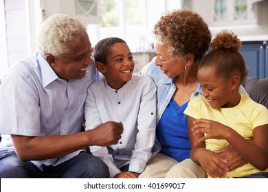 Grandparents and their young grandchildren relaxing at home