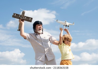 Grandson child and grandfather hold plane and drone quad copter against sky. Child pilot aviator with plane dreams of flying. Family Relationship Grandfather and child.