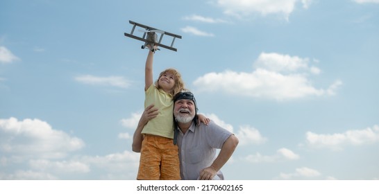 Grandson child and grandfather with toy plane over blue sky and clouds background. Two men generation grandfather and grandson playing outdoors. Generational family. - Shutterstock ID 2170602165