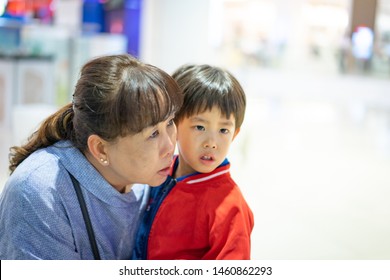 Grandson Is Crying, He Want To Buy Toys At The Department Store. Grandma Try To Teach Her Grandson To Understand Why She Can Not Buy Its.