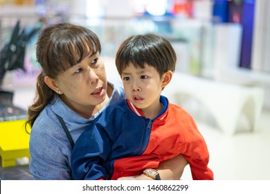 Grandson Is Crying, He Want To Buy Toys At The Department Store. Grandma Try To Teach Her Grandson To Understand Why She Can Not Buy Its.