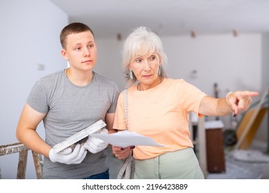 Grandson Helping Grandmother With Home Improvement, They Examining Plan Of Renovation And Planning Inner Works Together