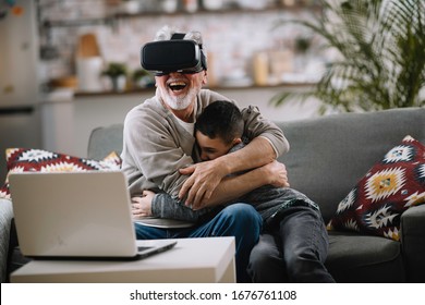 Grandson and his grandpa playing with VR at home on sofa. Grandfather and a little boy having fun in  living room. - Powered by Shutterstock