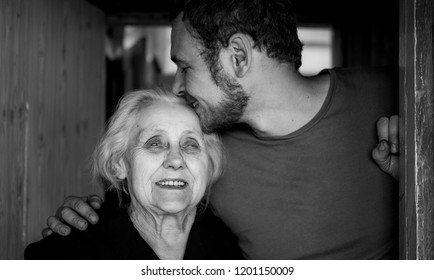 Grandson Kisses Her Grandmother. Black And White Photography