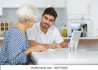 grandson showing senior woman online computer use