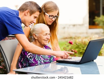 Grandson Showing Something To Grandma On The Computer.