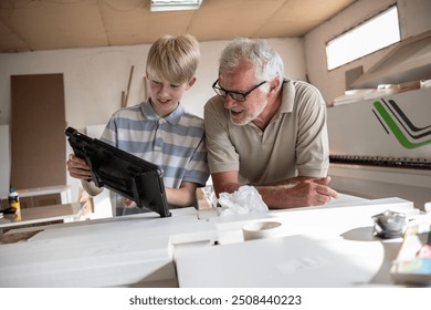 Grandson teaching his grandfather carpenter how to use a tablet to improve their work. The grandson shares his tech knowledge, helping the grandfather integrate modern tools into their craft.	
 - Powered by Shutterstock