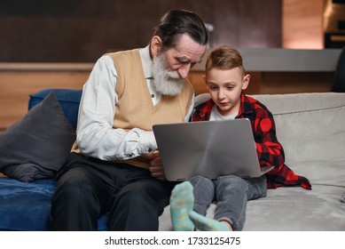 Grandson is teaching his grandfather to use laptop computer.