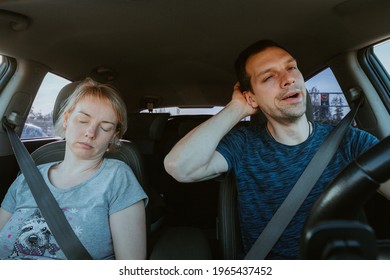 Grane Effect. Tired Yawning Man Driving A Car And Sleeping Woman Together During Road Trip. Passengers And Driver Wearing Seat Safety Belts Inside. Unsafe Vehicle Control, Danger Of Accident On Road.