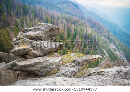Granit boulder on Moro Rock hiking track in Sequoia National Park, California, USA. Scenic view to Sequoia and Kings Canyon NP giant forests and foggy valleys landscape of Sierra Nevada mountain range