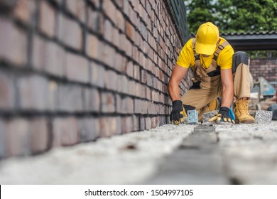 Granite Brick Paving Worker. Contractor Building Residential Driveway.