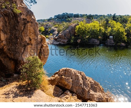 Granite Cliffs Reflecting on Inks Lake at Devils Waterhole, Inks Lake State Park, Texas, USA
