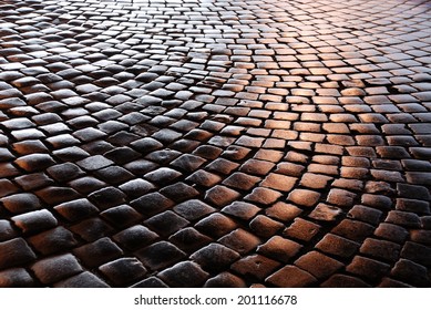 Granite Cobblestones Of The Belgian Block Pavement Are Photographed At Night.