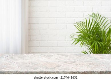 Granite countertop of several tones over white brick wall background - Shutterstock ID 2174641631