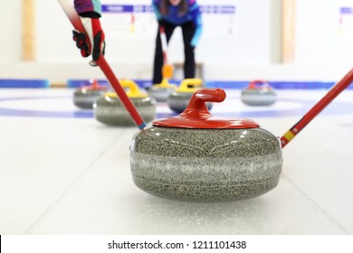 Granitpflastersteine.Auf dem Eis kurbeln. Team-Curling-Spiel.
