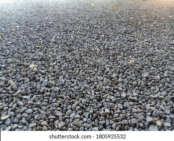 Granite gravel of macadam, rock gray crushed for construction on the ground. Scree texture background. Gravel is a loose aggregation of rock fragments.