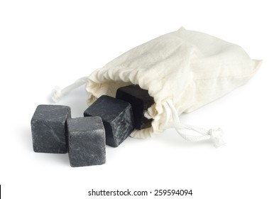 Granite ice cubes with textile pouch isolated on white background. Clipping path included.