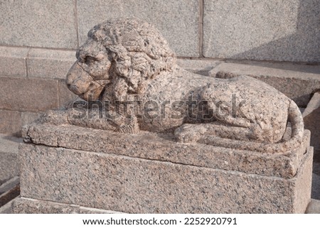 Granite sculpture of a reclining lion outside.