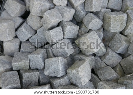 Granite stones for natural stone paving in the building materials trade for sale. Close-up
