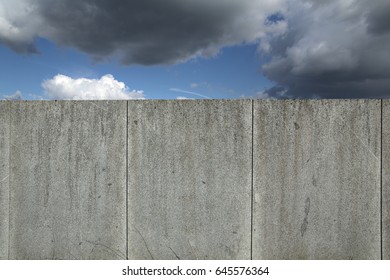 Granite wall with cloudscape and a blue sky.