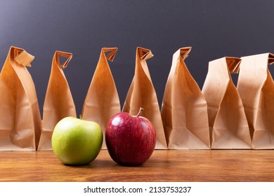 Granny Smith Apple And Apple By Paper Lunch Bags Arranged On Table Against Black Background. Unaltered, Healthy Food, Fruit And Packed Lunch.