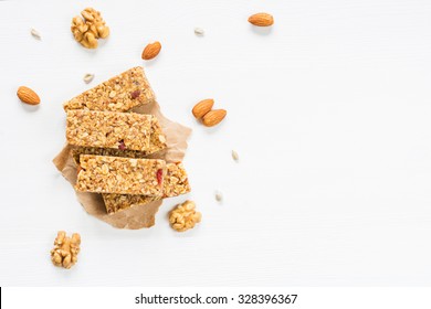 Granola Bar Or Energy Bar With Oats, Dates And Nuts On White Wooden Background, Top View