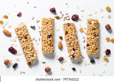 Granola bar. Healthy sweet dessert snack. Cereal granola bar with nuts, fruit and berries on a white stone table. Top view. - Shutterstock ID 797765212