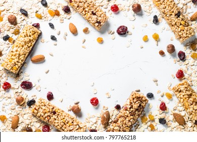 Granola Bar And Ingredients On A White Stone Table. Cereal Granola Bar With Nuts, Fruit And Berries. Top View Copy Space.