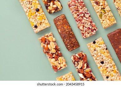 Granola bars.  Muesli. Healthy energy bars made of cereals, berries, nuts and fruits on a light green background. Space for the text. Copy space. Top view. - Powered by Shutterstock