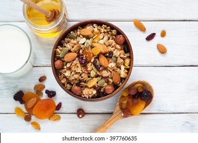 Granola Cereal Flakes With Dried Fruit, Nuts And Honey In A Wooden Bowl.