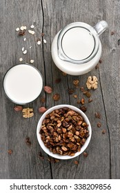 Granola cereal and milk on wooden background, top view