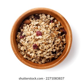 Granola with nuts and raisins in a wooden plate close-up on a white background. Top view