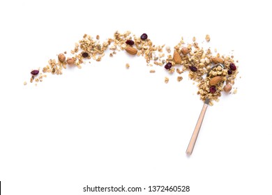 Granola on spoon isolated on white background, copy space. Healthy snack or breakfast concept - homemade granola with grains and nuts.