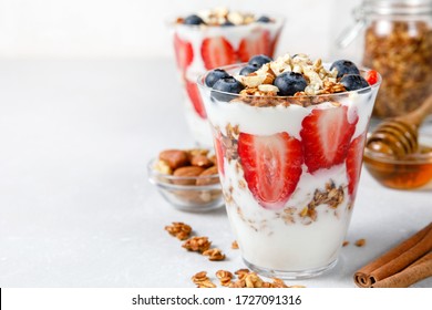 Granola Parfait with greek yogurt, oat granola, fresh berries, honey and mint leaves in tall glass jar. Healthy breakfast concept. Organic oat, almond and sunflower seeds. - Powered by Shutterstock