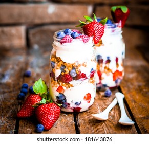 Granola Parfait With Yogurt And Berries On Rustic Background