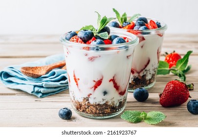 Granola parfait with yogurt, chocolate granola, fresh berries, and mint leaves - Powered by Shutterstock