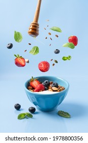 Granola With Yogurt And Berries In Bowl. Food Levitation. Healthy Breakfast. Blue Background, Side View