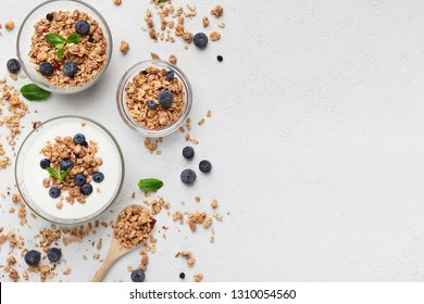 Granola, Yogurt, Blueberries In Bowls On Grey Background, Top View, Copy Space. Healthy Breakfast Menu Concept. Mockup