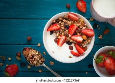 Granola. Granola with yogurt, honey and berries on blue wooden table. - Powered by Shutterstock