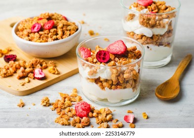 Granola and Yogurt Parfaits, Healthy Breakfast, Muesli with Dried Berries on Bright Concrete Background - Powered by Shutterstock