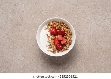 Granola with yogurt and strawberries in white bowl on  beige stone background with copy space. Top view quick healthy breakfast - Powered by Shutterstock