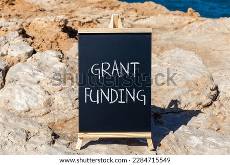 Grant funding symbol. Concept words Grant funding on black chalk blackboard on a beautiful stone background. Business and grant funding concept. Copy space.