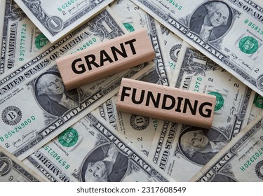 Grant funding symbol. Wooden blocks with words Grant funding. Beautiful dollar background. Business and Grant funding concept. Copy space.