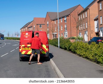 Grantham, Lincolnshire, England-March 17, 2022. Royal Mail Worker Closing Van Door Near Residential Houses On Penrhyn Way Street.